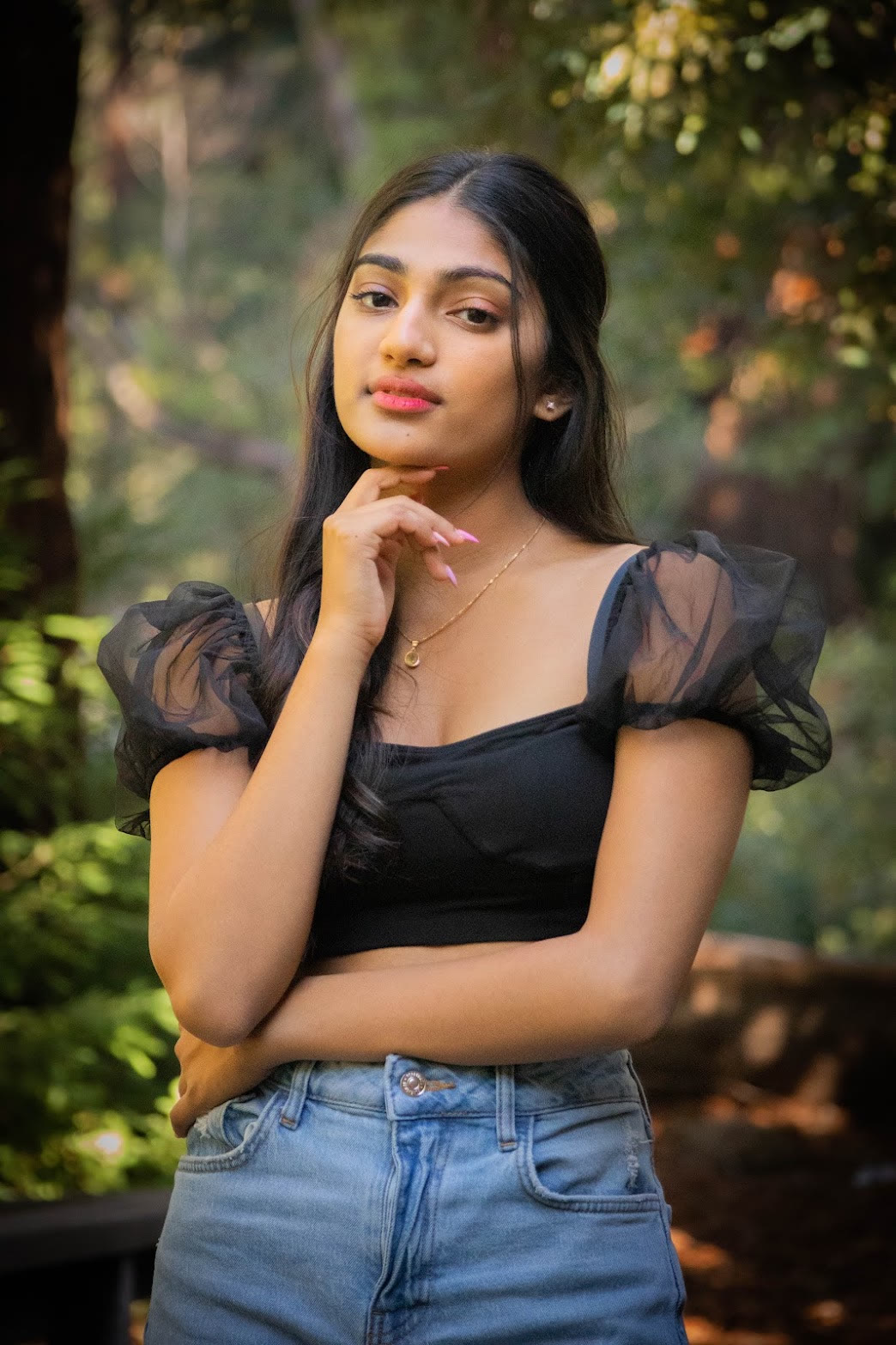 Lifestyle portrait of Mahika Valluri in a black tulle-sleeve top among redwoods