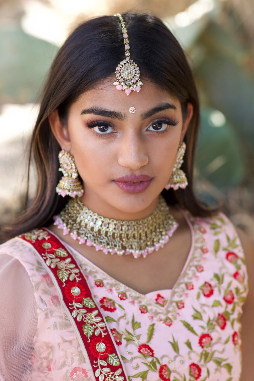 Close beauty portrait of Mahika Valluri in a pink embroidered blouse and gold jewelry